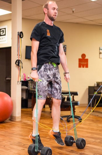 Athlete jumping with electrode pads on shins resulting in increased muscle activation due to the direct current Phoenix Waveform Neurotherapy